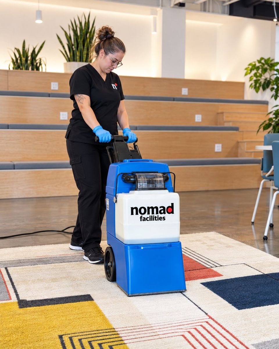 A Nomad Facilities team member deep cleaning carpet with an extractor